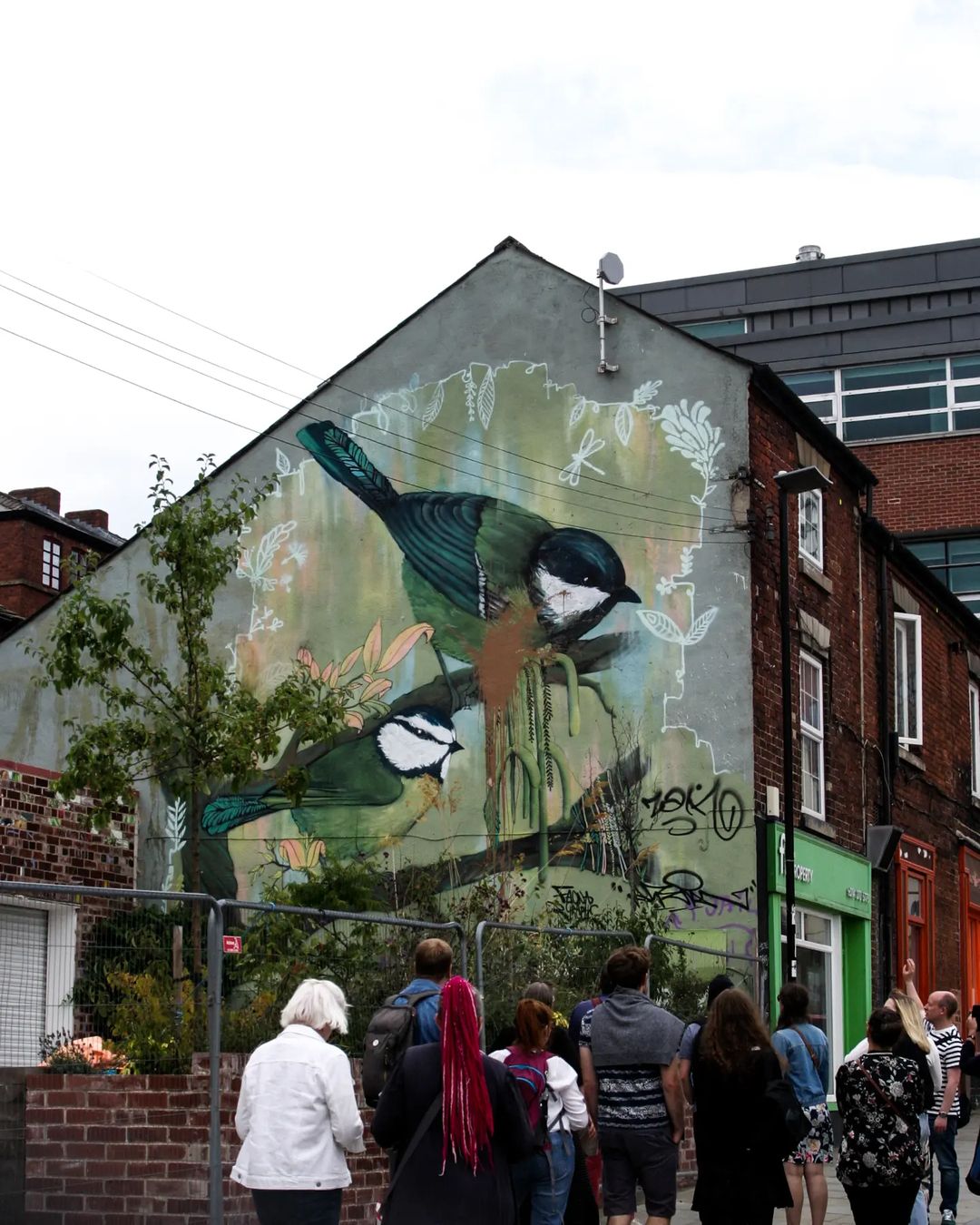 Tour group looking at a large wall mural by Faunagraphic